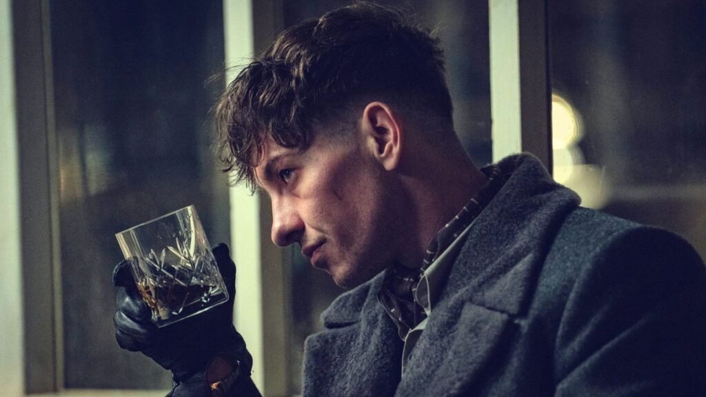 Barry Keoghan tips a whiskey glass towards a window
