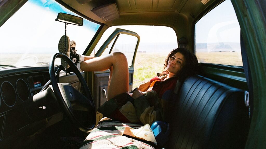 Learn how to watch Euphoria season 3 Zendaya's Rue smiling as she sits in a car with her feet on the steering wheel in Euphoria season 3