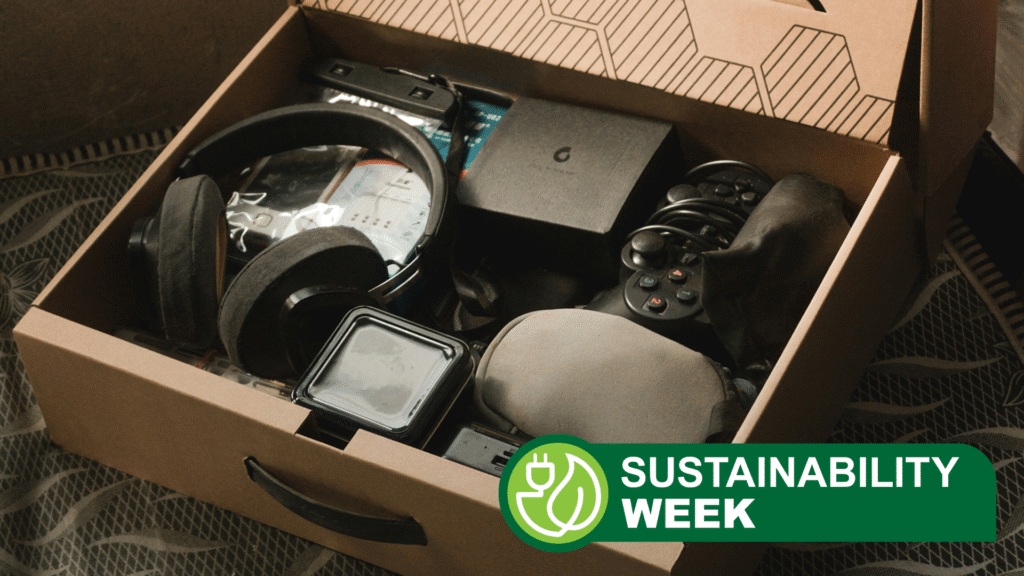 A cardboard box of old tech, including headphones, controllers and other devices