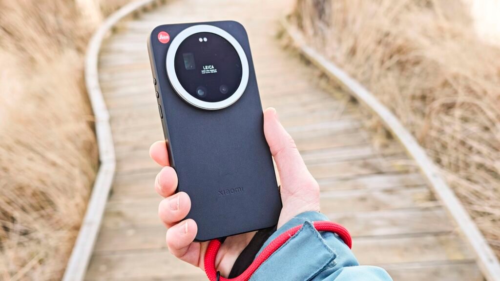 The Leica Leitzphone in person's hand with a wooden boardwalk backdrop