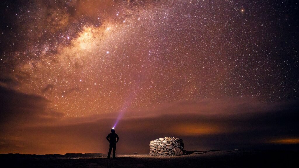 A man in the Atacama Desert staring into the night sky