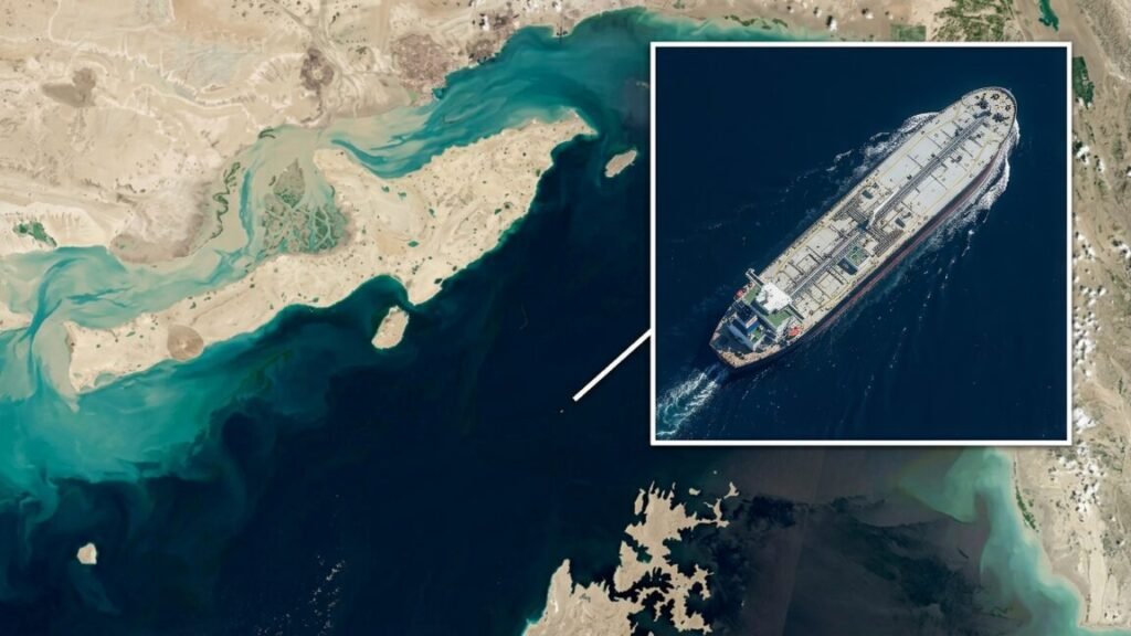 A top-down aerial or satellite image of the Strait of Hormuz with an inset image showing a large tanker ship in motion with a wake behind it.